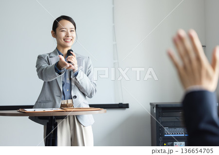 マイクを持って話す若い女性 136654705