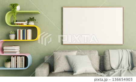 White frame and rainbow bookshelf hanging on green wall over grey sofa with cushions and blanket. White frame and rainbow bookshelf hanging on green wall over grey sofa with cushions and blanket. 136654903