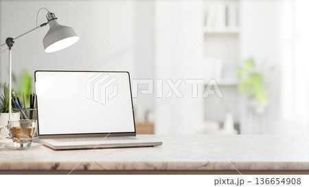 White screen laptop with coffee aside pencil storage and lamp on marble counter table in bright room White screen laptop with coffee aside pencil storage and lamp on marble counter table in bright room 136654908