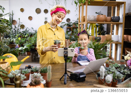 A mother and daughter are filming a video about succulents in a plant shop A mother and daughter are filming a video about succulents in a plant shop 136655053