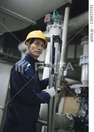ビル設備の機械室で働く作業員 ビル設備の機械室で働く作業員 136655591