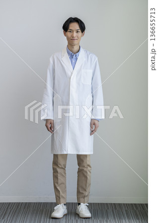 カメラ目線で微笑む白衣を着た30代の男性　全身　白バック　ポートレート 136655713
