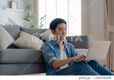 Young Asian man relaxing on comfortable couch Young Asian man relaxing on comfortable couch 136656906