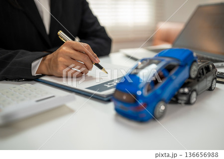 Female signing car insurance document or lease. Female signing car insurance document or lease. 136656988