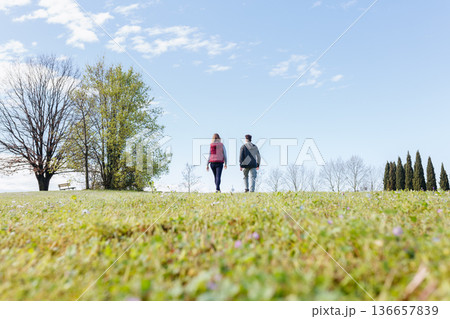 rear view of two persons walking in the park 136657839