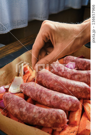 Natural casing sausages being prepared with vegetables in a cozy kitchen setting Natural casing sausages being prepared with vegetables in a cozy kitchen setting 136657966