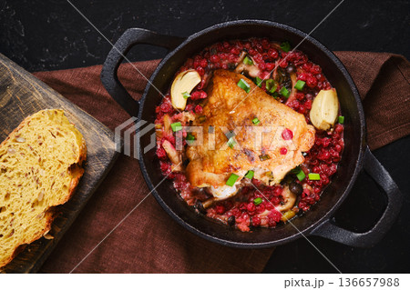 Cooking chicken in a pot with vegetables and bread on a wooden board Cooking chicken in a pot with vegetables and bread on a wooden board 136657988