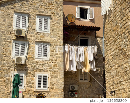 Laundry drying on a clothesline outside a residential building. Everyday life, domestic routine and urban simplicity in Mediterranean architecture. 136658209