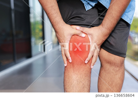 Asian man suffering from severe knee pain with red inflamed area. Concept of osteoarthritis, meniscus injury, gout, rheumatoid arthritis, and orthopedic medical treatment in adult patients. 136658604