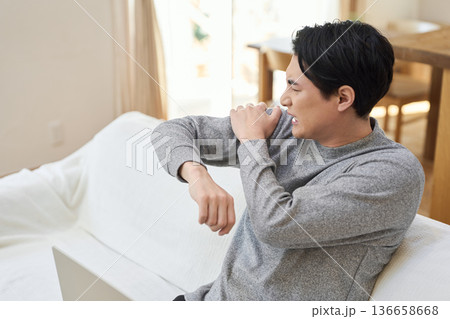 肩が痛くて腕を回すアジア人男性 肩が痛くて腕を回すアジア人男性 136658668