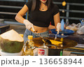Preparation of pancakes sweet roti at a street stall in Bangkok, showcasing a traditional Thai snack being made by a local vendor in the evening. High quality photo 136658944