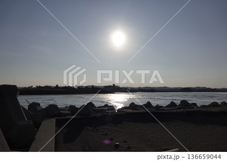 夕陽の反射でキラキラと輝く水面と対岸の風景 夕陽の反射でキラキラと輝く水面と対岸の風景 136659044