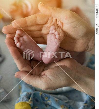 Mother touching small baby feet. 136660158