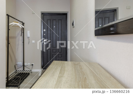 Modern Home Entrance with Wooden Console Table and Black Door Modern Home Entrance with Wooden Console Table and Black Door 136660216