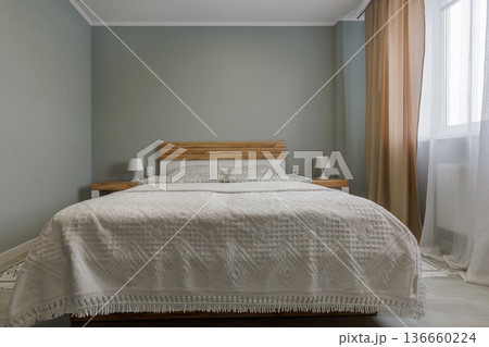 Symmetrical Bedroom Interior with Wooden Headboard and Green Walls 136660224