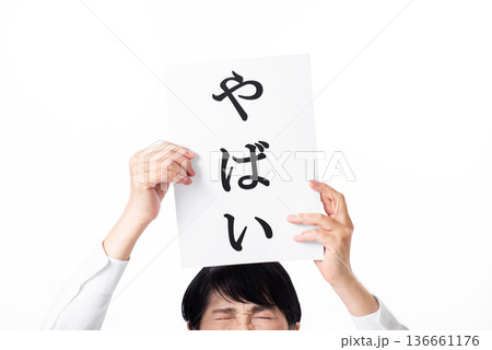 やばいと書かれた紙を両手で掲げるシニア女性 136661176