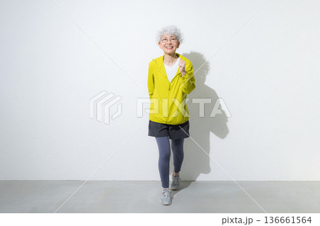 スポーツウェアで走るポーズをするお洒落なグレイヘアのアクティブシニアの女性 136661564