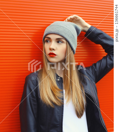 modern young woman in hat, black jacket, stylish girl posing on city street modern young woman in hat, black jacket, stylish girl posing on city street 136661744