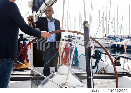 two male business partners celebrating the purchase on a yacht in the seaport two male business partners celebrating the purchase on a yacht in the seaport 136662923