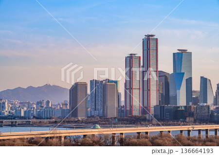 Seoul, Korea - Feb. 16, 2026 : A building in Yeouido, Seoul's financial district in Korea, taken just before sunset, and the cityscape of the Han River 136664193
