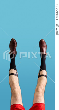Brown leather men shoes with garter straps and black socks on blue background 136665455