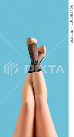 Nude high heels and black mesh socks crossed legs pose on blue background. Nude high heels and black mesh socks crossed legs pose on blue background. 136665456