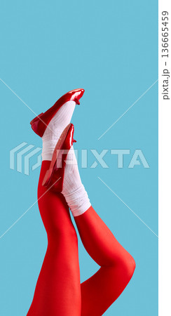 Female legs in red tights and red patent shoes on blue background. Female legs in red tights and red patent shoes on blue background. 136665459