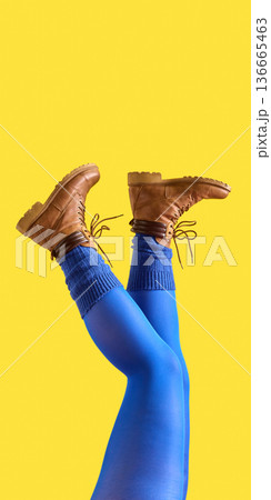 Female legs in blue tights and brown boots on yellow background Female legs in blue tights and brown boots on yellow background 136665463