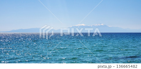 The clear turquoise water of a warm sea under a clear blue sky 136665482