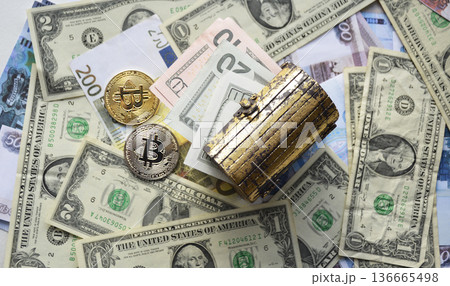 Two Bitcoin coins and a wooden chest against a background of dollars Two Bitcoin coins and a wooden chest against a background of dollars 136665498