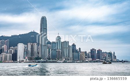 Hong Kong panoramic cityscape Victoria Harbour International Finance Centre skyscrapers urban skyline water transportation boat crossing harbour daytime cloudy blue sky Hong Kong panoramic cityscape Victoria Harbour International Finance Centre skyscrapers urban skyline water transportation boat crossing harbour daytime cloudy blue sky 136665559