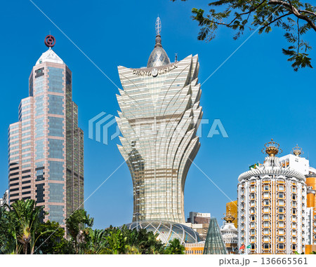 MACAU CHINA - DECEMBER 27 2025: Grand Lisboa hotel tower and Bank of China building standing together in Macau city skyline under bright blue sunny sky outdoors 136665561