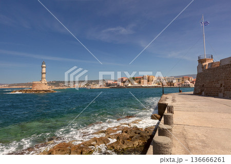 Sunny Seaside Promenade Leading Toward Venetian Lighthouse in Chania Crete Greece Sunny Seaside Promenade Leading Toward Venetian Lighthouse in Chania Crete Greece 136666261