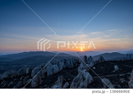 黄昏時のカルスト台地：山焼き後の広大なパノラマと夕光 136666908