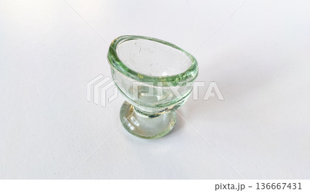 Vintage green transparent glass eye wash cup isolated on white background. Top view. Medicine concept 136667431