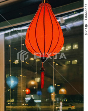 Red lantern inside cafe near window, city lights reflection at night, warm interior scene. Concept of asian lantern decor, chinese lantern lighting, night reflection, festive interior background Red lantern inside cafe near window, city lights reflection at night, warm interior scene. Concept of asian lantern decor, chinese lantern lighting, night reflection, festive interior background 136668433