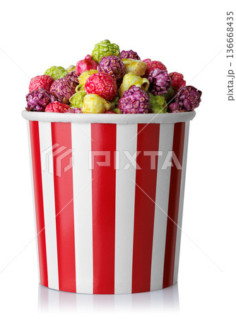 Caramelized fruit popcorn in red and white striped paper bucket isolated on white 136668435