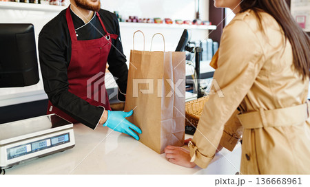 Customer receives takeout order at a busy restaurant in the afternoon 136668961