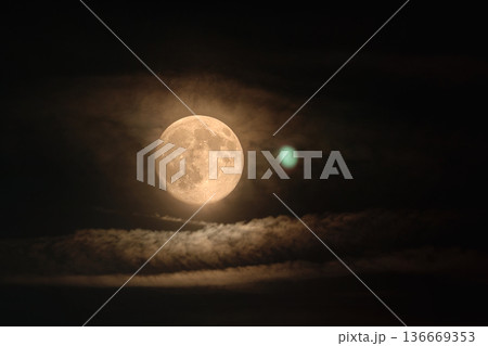 Full Moon Behind Thin Clouds in Dark Night Sky 136669353