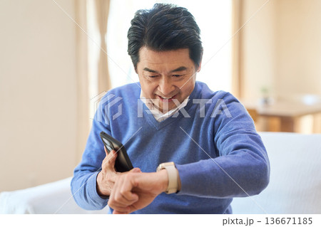 スマートデバイスからの通知を見るアジア人シニア男性 136671185