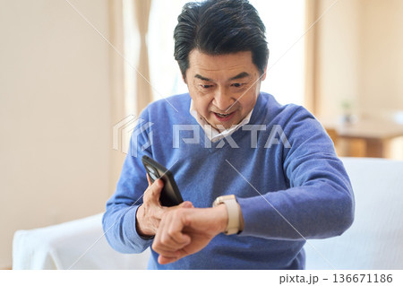 スマートデバイスからの通知を見るアジア人シニア男性 136671186