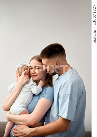 Parents holding baby in home setting during daytime while sharing a moment together Parents holding baby in home setting during daytime while sharing a moment together 136671827