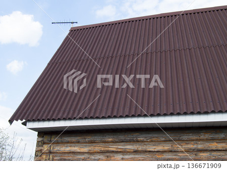 modern construction of the roof with red metal siding to a wooden house in the garden modern construction of the roof with red metal siding to a wooden house in the garden 136671909