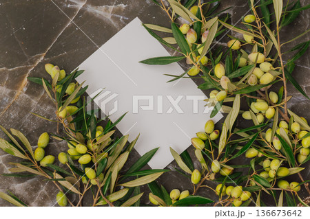 Premium olive oil branding mockup with fresh green olives on marble. Blank white card for logo text 136673642
