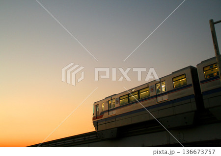 夕焼けの中を走る大阪モノレール 136673757