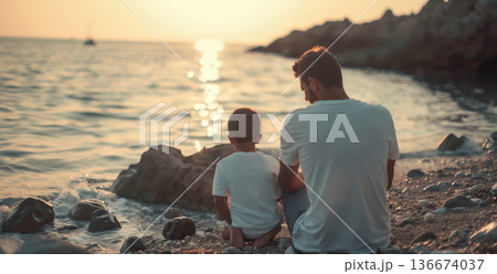 back view of father and child sitting by sea on beach, family vacation concept, togetherness of parents and kids 136674037