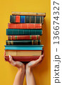 person hand holding stack of colorful books, study and education, intelligence and learning concept 136674327