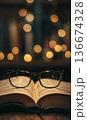 reading eyeglasses lying on open book page in university library or school, intelligence and education, study and learning concept 136674328