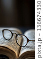 reading eyeglasses lying on open book page in university library or school, intelligence and education, study and learning concept 136674330