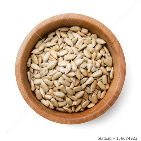 Peeled sunflower seeds, sunflower kernel in a wooden plate on a white background. Top view Peeled sunflower seeds, sunflower kernel in a wooden plate on a white background. Top view 136674922